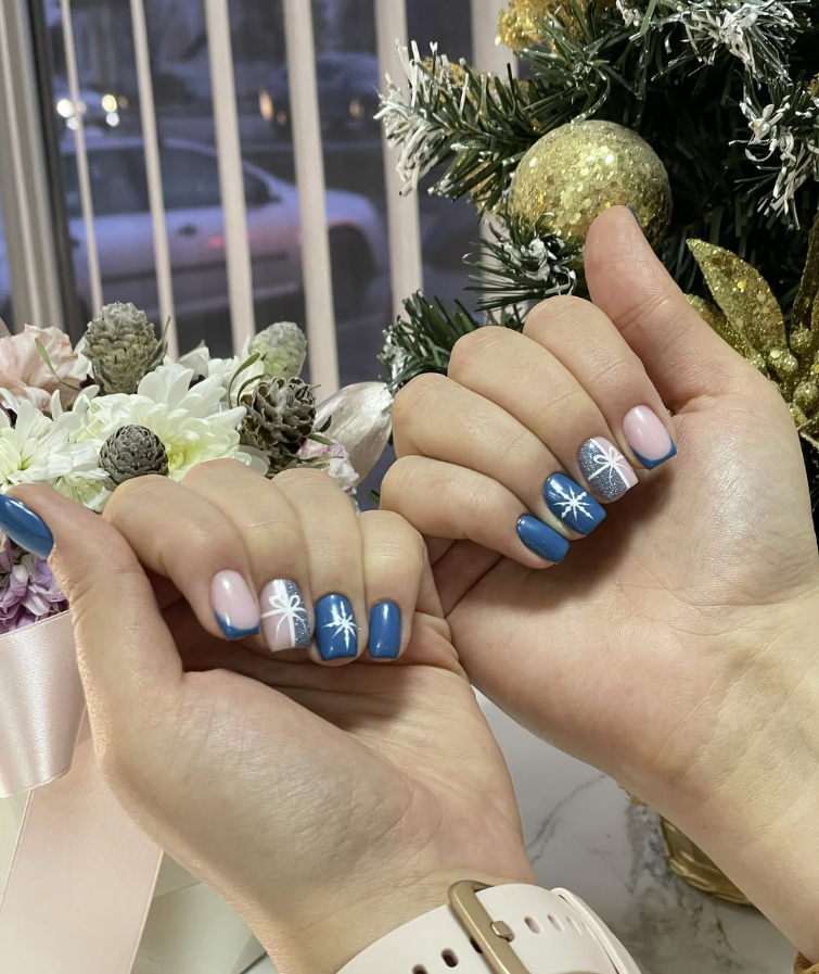 Festive blue gel manicure with silver glitter snowflake art