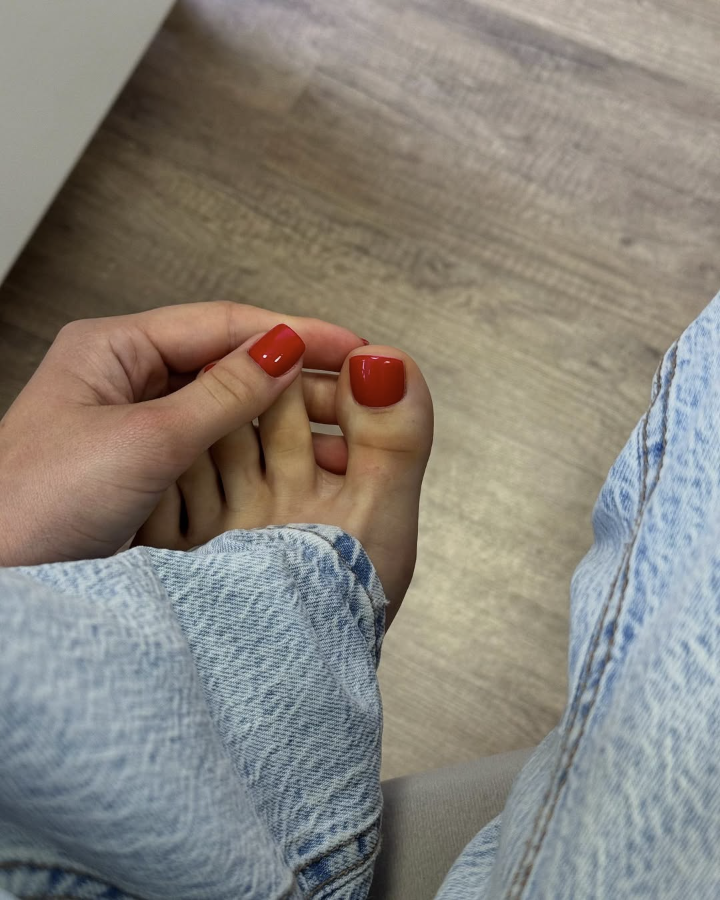Coral red pedicure on summer toes